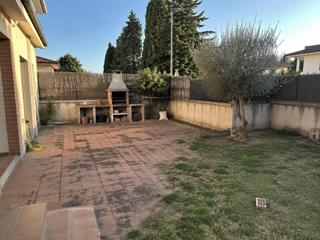 Jardín de chalet con barbacoa de obra antigua antes de la reforma