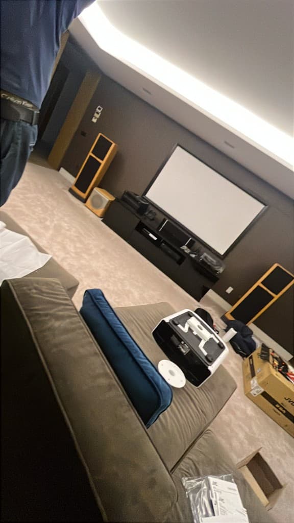 Instalación de cine en casa con pantalla, altavoces y proyector en chalet