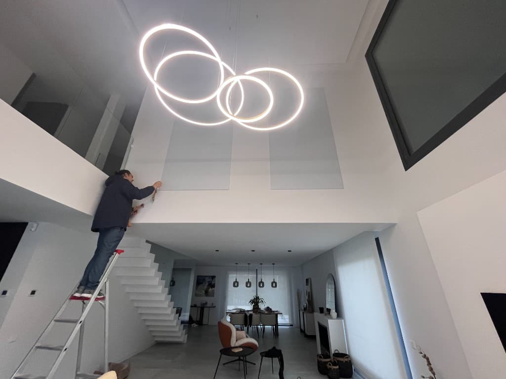 Reforma de chalet de doble altura con escalera, ventanas y operario en obra